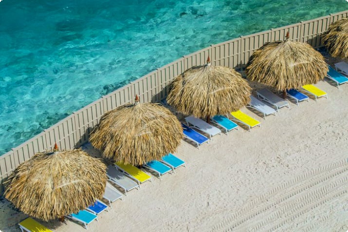 De Palm Island'daki plaj çardakları ve şezlonglar