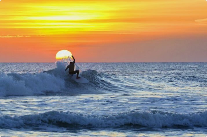 Серфер на закате на пляже Кута