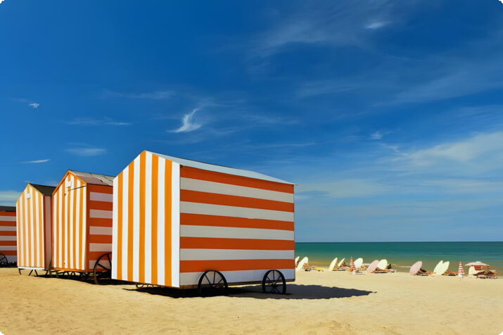 Красочные пляжные домики на пляже Де Панн
