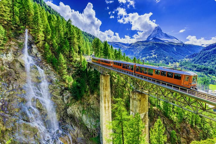Trem cruzando uma ponte na Suíça com o Matterhorn à distância