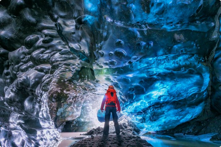 Путешественник в ледяной пещере в Ватнайокудле, Исландия