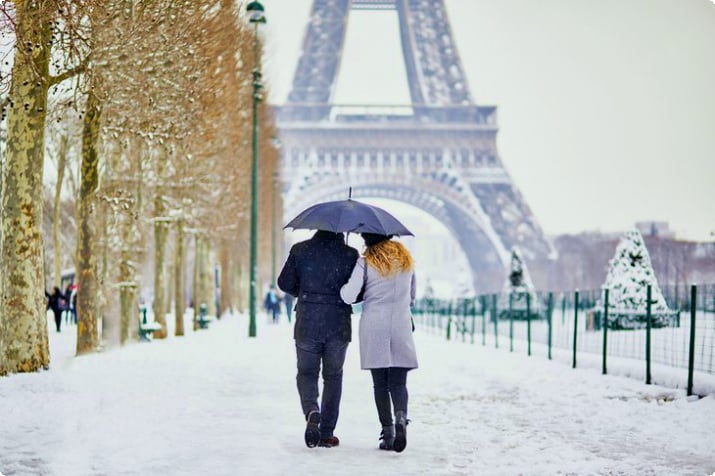 Coppia che cammina sulla neve durante l'inverno a Parigi