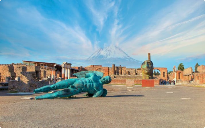 Statue a Pompei con il Vesuvio in lontananza