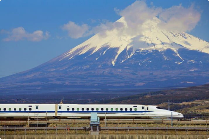 Скоростной поезд проезжает мимо горы Фудзи