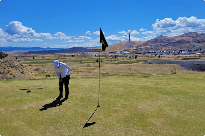 Golfing at Old Works mit der Schmelze im Hintergrund