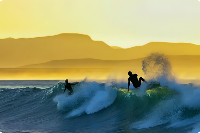 Surfare njuter av Supertubes vid soluppgång