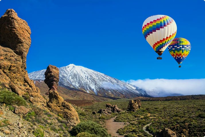 Balões de ar quente com o vulcão Teide coberto de neve no Parque Nacional Teide, Tenerife